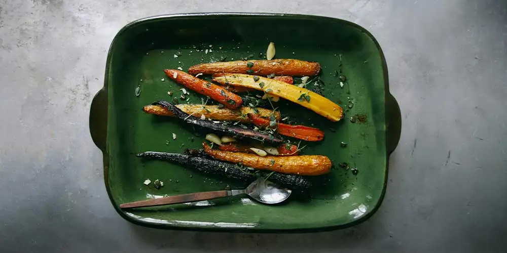 cooked carrots in a green dish