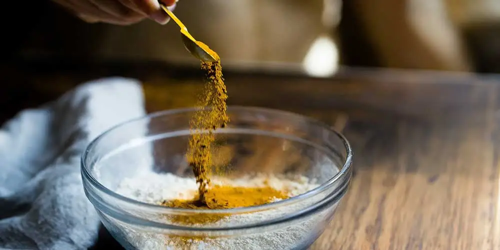 turmeric spice being added to bowl